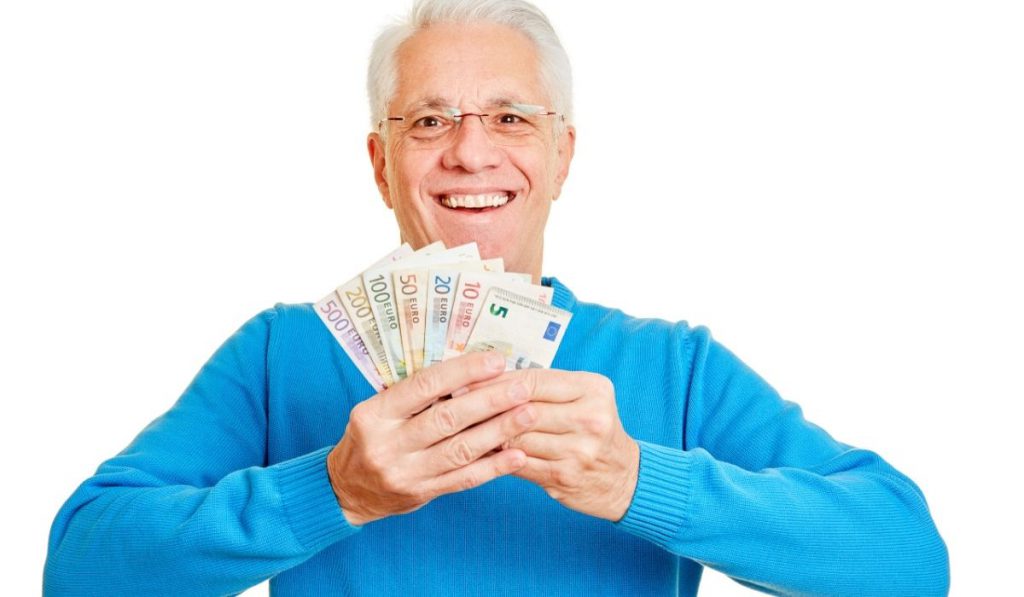 a happy grandpa showing money that he saved while renting on a storage facility