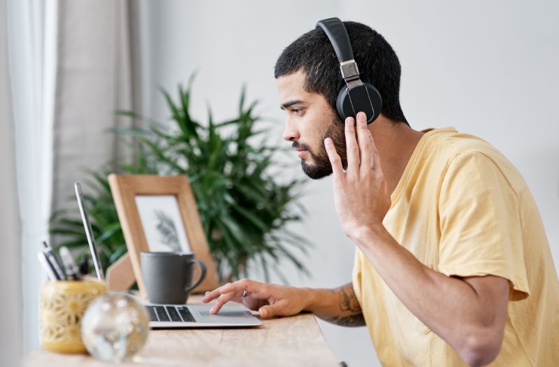 guy using his laptop and noise cancelling headset