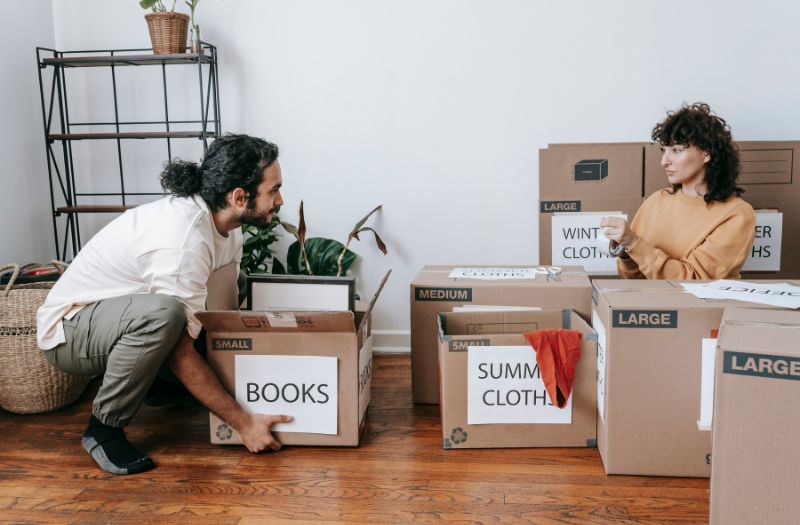 couple labelling their moving boxes